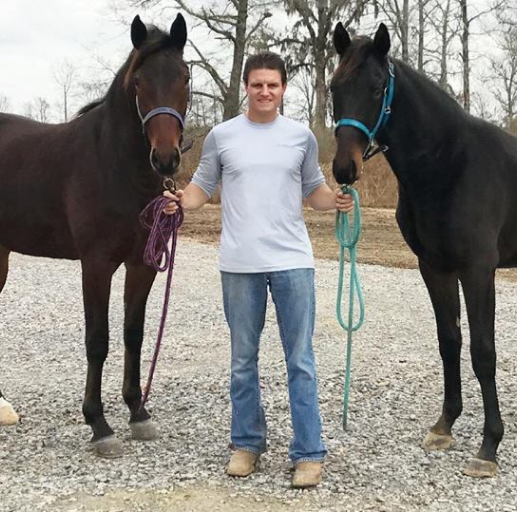 a man stands with 2 horses